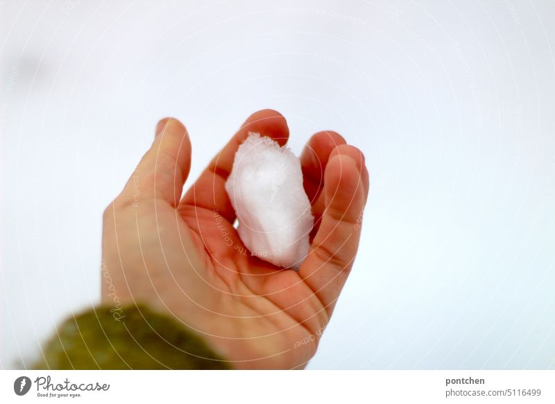 ein kleiner schneeball in einer hand. schneeballschlacht. winter r halten kalt Außenaufnahme Freude weiß Spielen