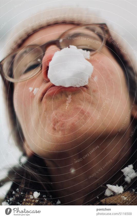 ein schneeball im gesicht einer frau. schneeballschlacht winter treffer Schnee Außenaufnahme Freude Fröhlichkeit