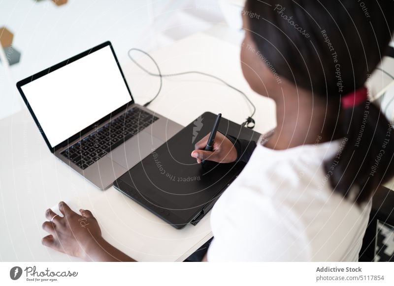 Schwarzer Illustrator zeichnet auf Grafiktablett Frau Zeichner zeichnen Tablette Laptop benutzend kreativ leerer Bildschirm Heimarbeitsplatz Projekt schwarz