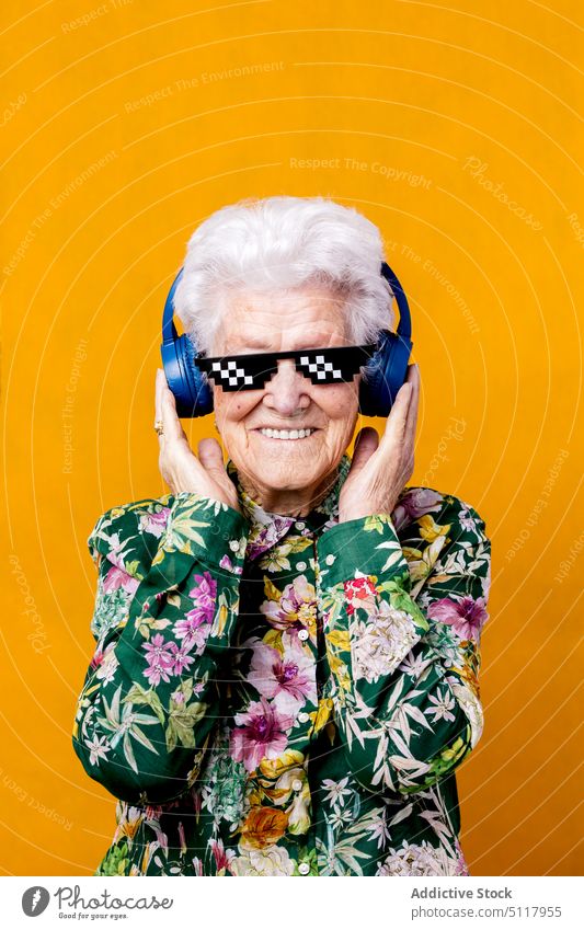 Ältere Frau mit Pixel-Sonnenbrille hört Musik zuhören Bildpunkt cool Lächeln Glück farbenfroh hell älter Senior gealtert Rentnerin in den Ruhestand gehen