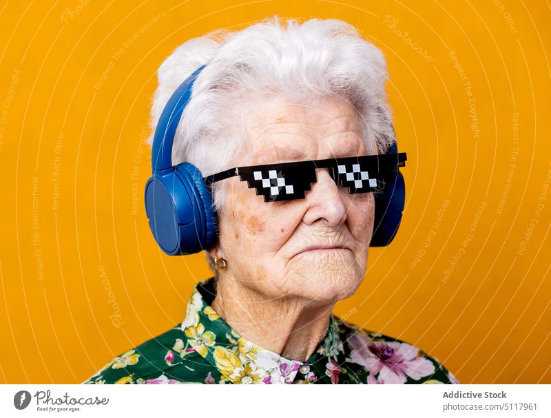 Stilvolle ältere Frau beim Musikhören zuhören meloman geblümt Ornament cool hell farbenfroh Senior gealtert Rentnerin in den Ruhestand gehen Klang lebhaft