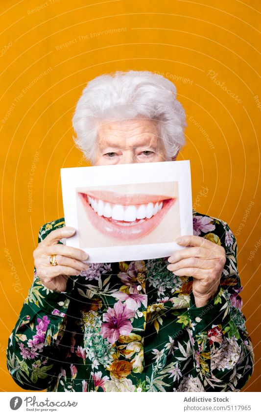 Ältere Frau mit Foto eines Lächelns Zahnfarbenes Lächeln Deckblatt zeigen Stil Zahnmedizin Glück farbenfroh hell älter Senior gealtert in den Ruhestand gehen