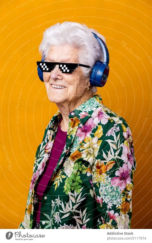 Ältere Frau mit Pixel-Sonnenbrille hört Musik zuhören Bildpunkt cool Lächeln Glück farbenfroh hell älter Senior gealtert Rentnerin in den Ruhestand gehen