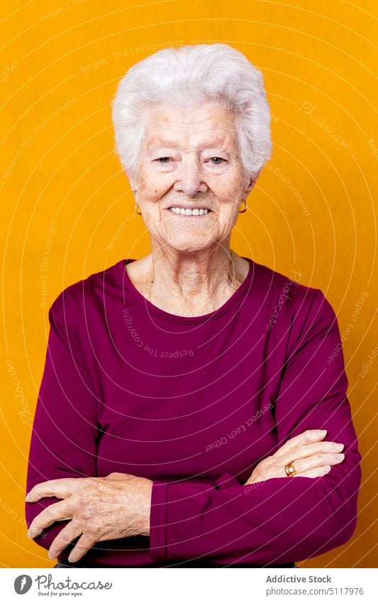Positive ältere Frau mit verschränkten Armen Lächeln lässig Glück Rentnerin Stil graues Haar Vorschein farbenfroh hell Senior gealtert in den Ruhestand gehen