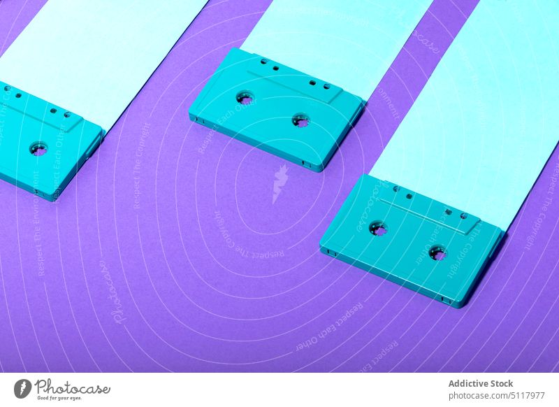 Helle Kassettenbänder auf blauen Streifen Klebeband Zusammensetzung hell farbenfroh Audio Paar Kunststoff Klang pulsierend stereo Accessoire lebhaft analog
