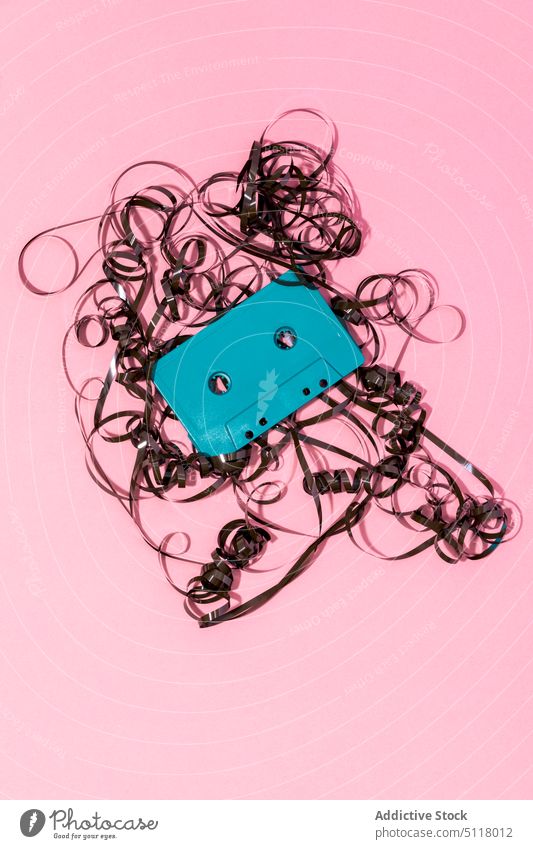 Retro-Kassette mit verheddertem Band auf rosa Oberfläche Klebeband retro Wirrwarr Musik 90s altehrwürdig hell Nostalgie zuhören altmodisch analog Streuung