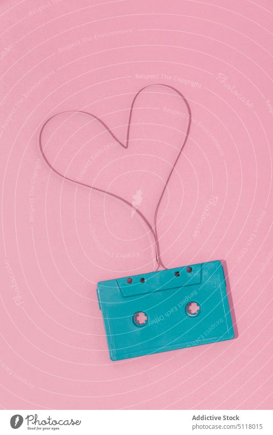 Retro-Kassette mit herzförmigem Band auf rosa Oberfläche Herz Klebeband retro Musik Audio Symbol Nostalgie Aufzeichnen analog Form 90s Kunststoff stereo Gesang