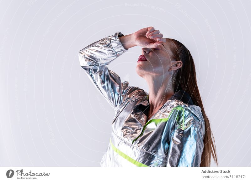 Stilvolle Frau in holografischer Jacke Model Augen abdecken Make-up trendy Körperhaltung modern Vorschein cool Persönlichkeit Outfit jung feminin Individualität