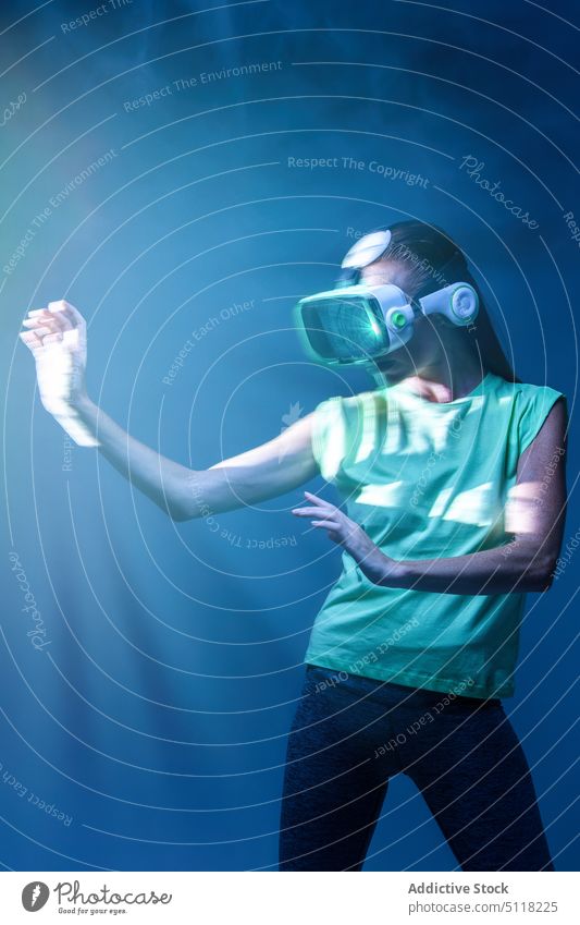 Frau spielt VR-Spiel in Neonlicht Videospiel Virtuelle Realität Headset neonfarbig spielen Rauch Schutzbrille Licht unterhalten Innovation Erfahrung