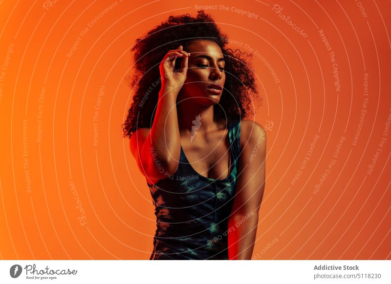 Ethnische Frau schaut nach unten und berührt die Stirn ruhig Stil Vorschein Model Afro-Look Tastkopf kosmisch krause Haare Atelier Persönlichkeit Windstille
