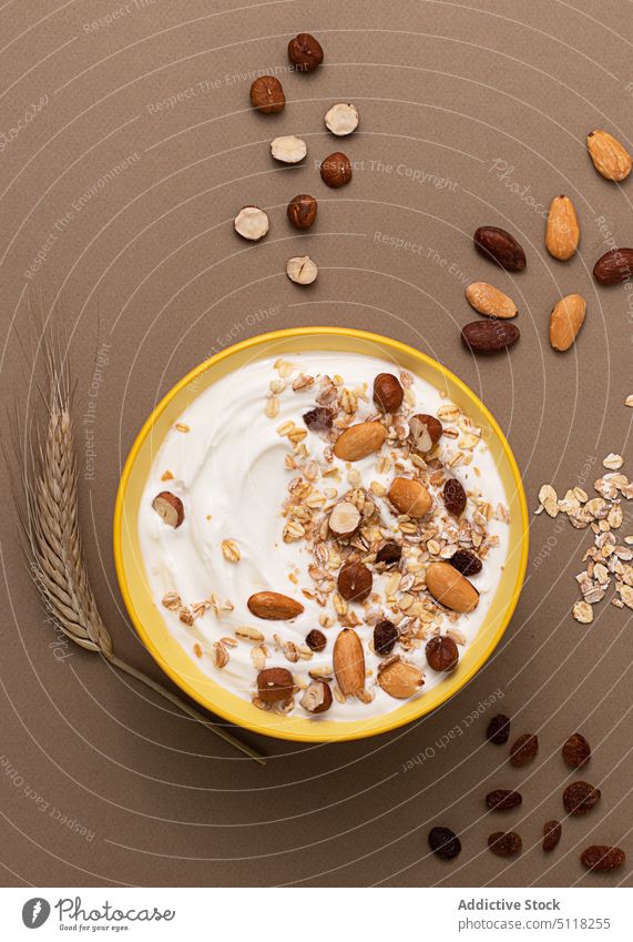 Joghurt, serviert mit Haferflocken und getrockneten Nüssen Bio-Lebensmittel Zerealien Saatgut Rosine Nut Morgen Schalen & Schüsseln Braunpapierstruktur Mandeln