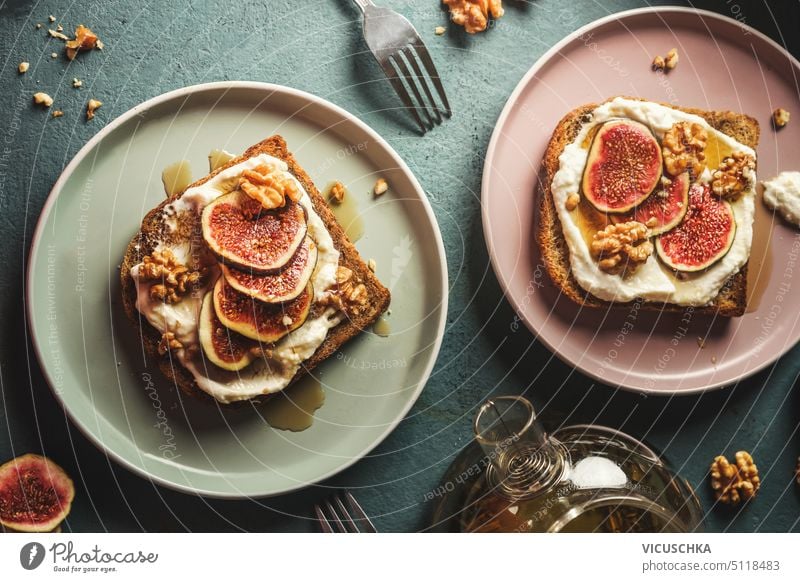 Frühstücks-French-Toasts mit frischer Sahne, Feigenscheiben und Nüssen, in Ahornsirup getränkt auf Tellern, Ansicht von oben französische Toasts Creme frisch