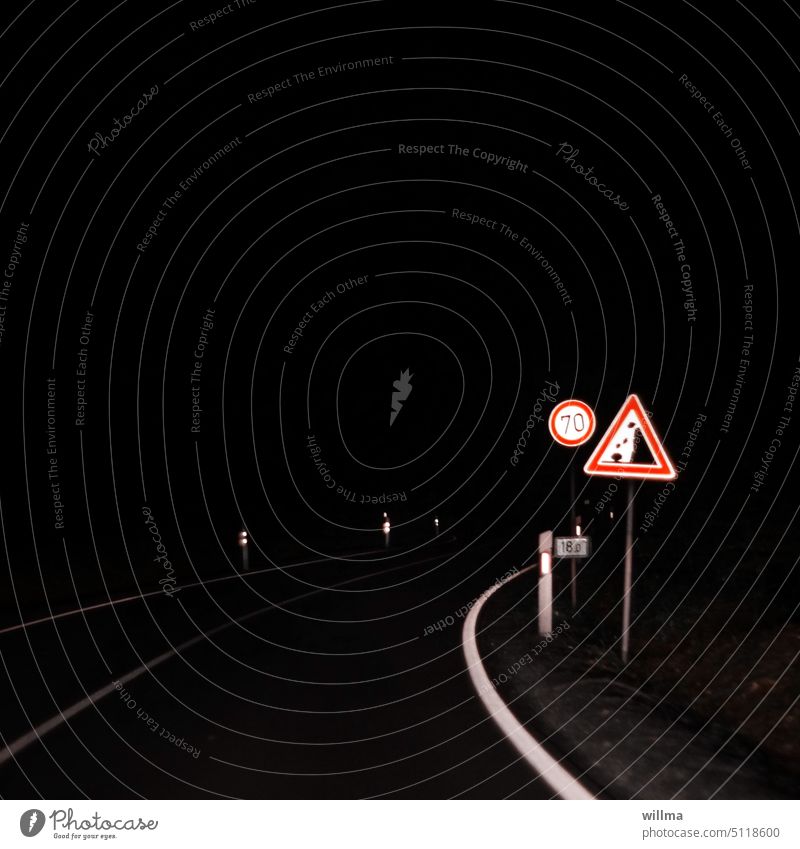 Nachtfahrt, Landstraße in der Nacht mit Verkehrsschildern am Straßenrand Steinschlag Tempolimit 70 dunkel schwarz Textfreiraum Leitpfosten Fahrbahnmarkierung