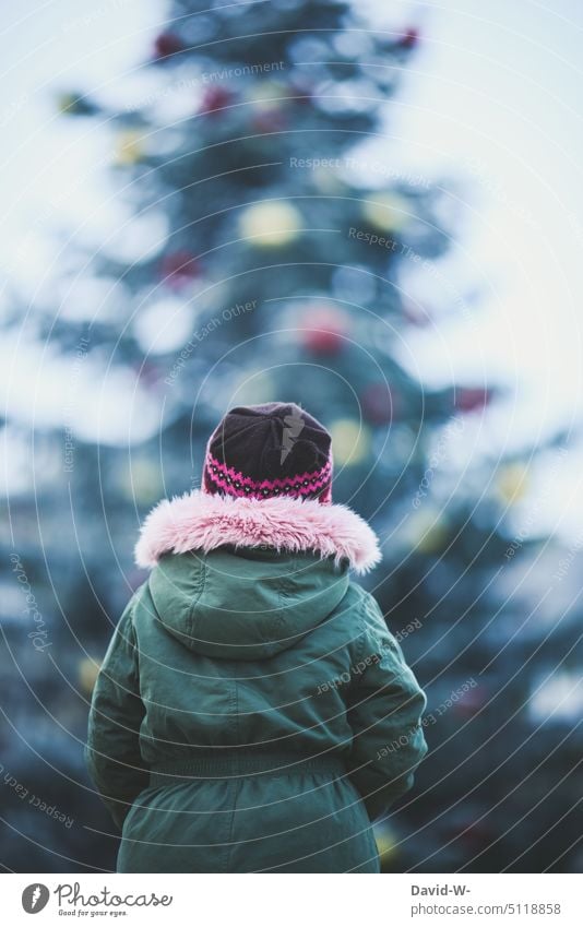 Kind steht vor einem großen Weihnachtsbaum im Winter zu Weihnachten Gedanken Weihnachten & Advent weihnachtlich Vorfreude wünschen Wunsch nachndenklich denken
