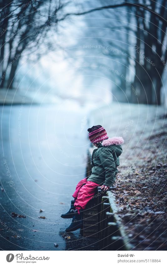 Gefahr - Mädchen im Winter an einem zugefrorenem Fluss Eis See Kind einbrechen neugierig Gefahrenstelle Winterstimmung Wintertag frostig Neugier Frost tasten