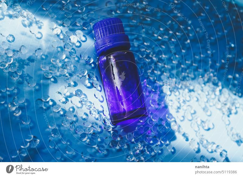 Essenzielles Bio-Öl in einer dunkelblauen Flasche vor einem eleganten blauen Hintergrund notwendig Erdöl Gesundheit frisch Diamant Wasser Stillleben Objekt