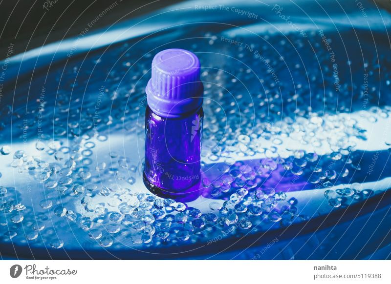 Essenzielles Bio-Öl in einer dunkelblauen Flasche vor einem eleganten blauen Hintergrund notwendig Erdöl Gesundheit frisch Diamant Wasser Stillleben Objekt