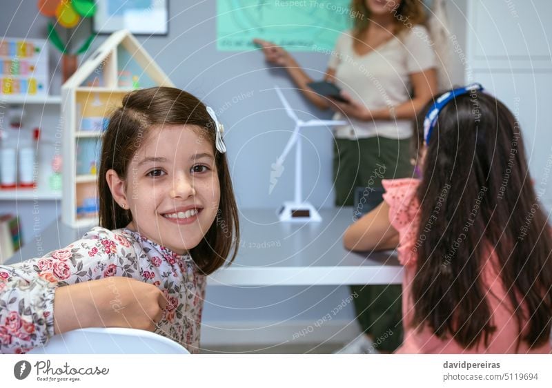 Porträt einer Schülerin im Ökologie-Klassenzimmer und Lehrer, der den Unterricht im Hintergrund erklärt Frau Schulmädchen Mädchen in die Kamera schauen Blick