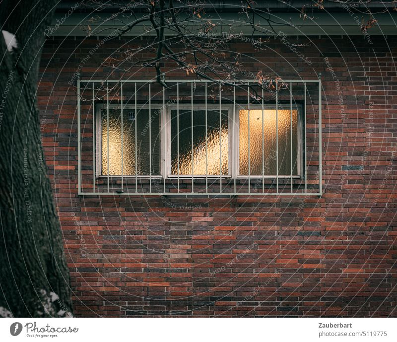 Fenstergitter, Fenster in Ziegelwand, Lichtspiel in Ornamentglas Glas Gitter Wand Winter städtisch Bauwerk Geheimnis geheimnisvoll Mauer Fassade rot Backstein