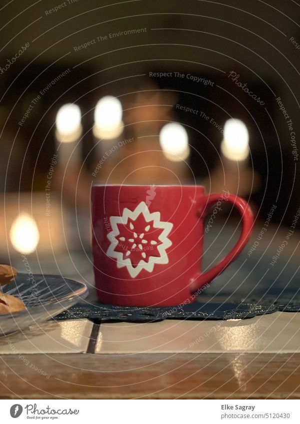 Eine rote Tasse mit Stern und Kerzenlicht im Hintergrund rote tasse Kaffeetasse Heißgetränk Farbfoto Innenaufnahme Nahaufnahme Frühstück Kaffeepause
