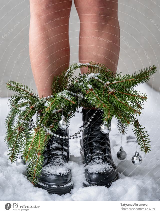 Person Beine in schweren Stiefeln mit Weihnachtsbaumzweigen Weihnachten dekoriert Schnee Winter Niederlassungen schneebedeckt Konzept klobig Blumenstrauß