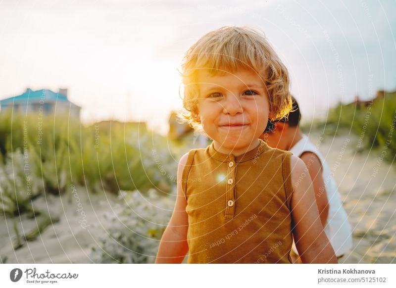 Porträt von niedlichen kleinen Jungen auf natürlichen Hintergrund. Sommer sonnigen Tag. Kleinkind. Natürliche ästhetische Porträt des Kindes. Goldene Stunde. Lächelndes Kind.