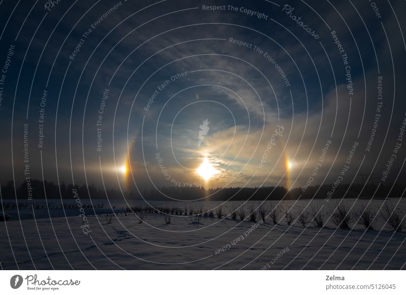 Sonnenuntergang im Winter und natürliches atmosphärisches Phänomen Halo, Nebensonne, Nebensonnen, Sonnenhund in Lettland Parhelia Heiligenschein sundog