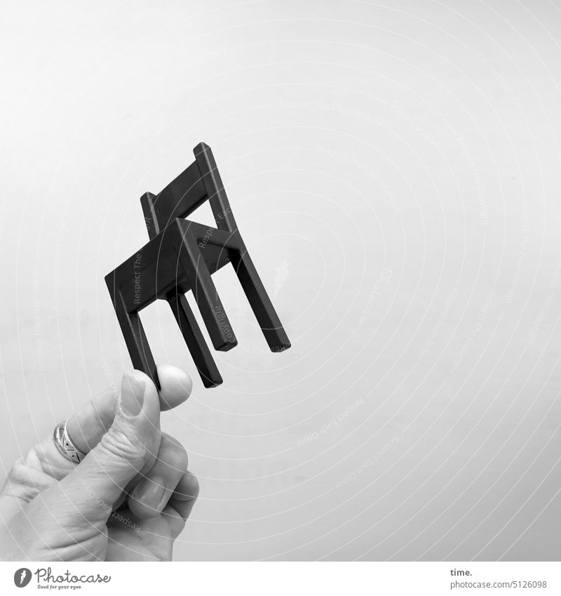 auf der Kippe | Klemmsicherung Stühl Stühlchen Miniatur Hand halten schwarz Ring Finger Schräglage Möbelstück Sitzgelegenheit