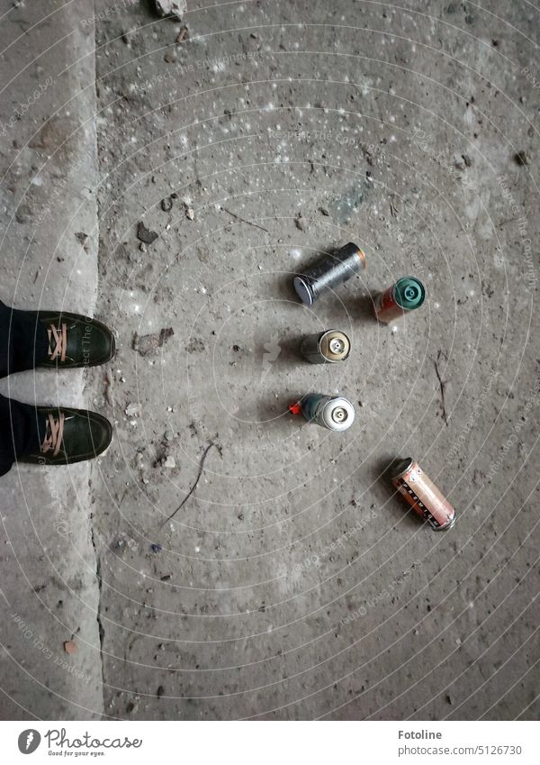 Leere Farbdosen liegen auf dem grauen Boden vor meinen Füßen. Irgendwo ist dieser Lost Place bunter geworden. Nur den Müll hätten die Künstler wieder mitnehmen sollen.