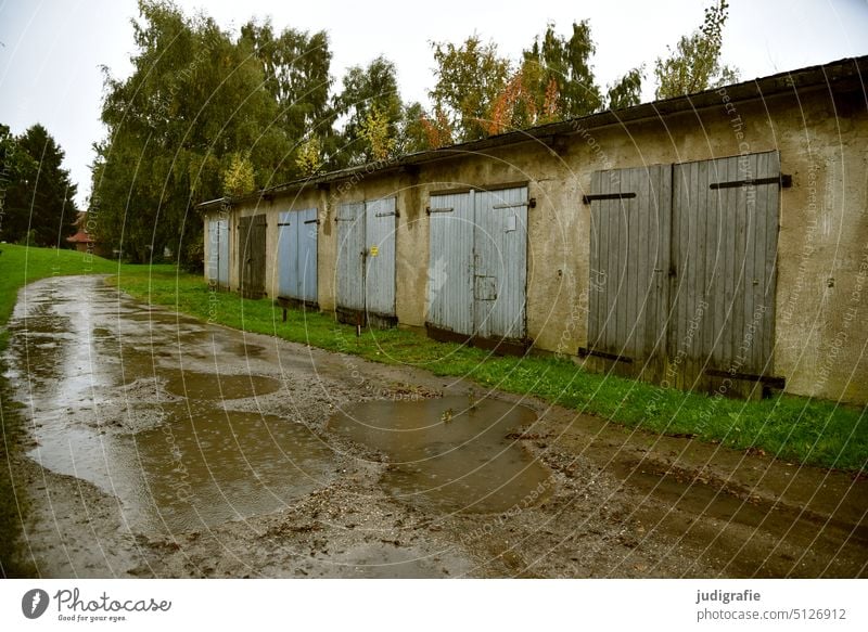 Regen vorm Garagenkomplex Garagentor Garagentore Herbst Pfützen Wetter schlechtes Wetter Einfahrt trist Schmuddelwetter Tor Holztor Tür