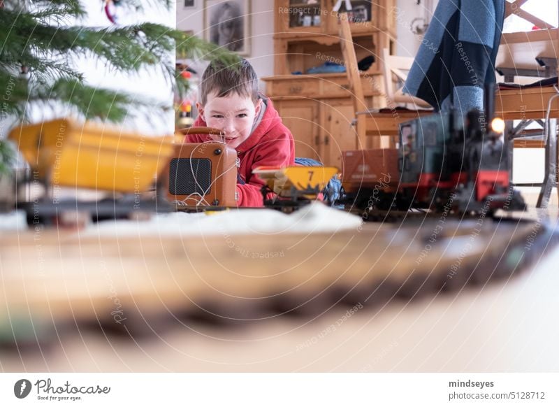 Spielen mit der Modelleisenbahn Weihnachten zu Hause Zug unterm Weihnachtsbaum elektrische Eisenbahn Spielzeug festlich freude Kindheit Kindheitstraum