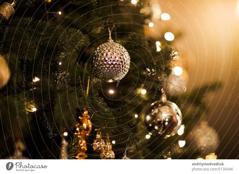 Nahaufnahme von schönen Tannenzweigen mit glänzenden goldenen Kugel oder Ball, Weihnachtsschmuck und Lichter, Weihnachtsferien Hintergrund. copy space. Dekoration auf Weihnachtsbaum. Festliche neue 2023 Jahr