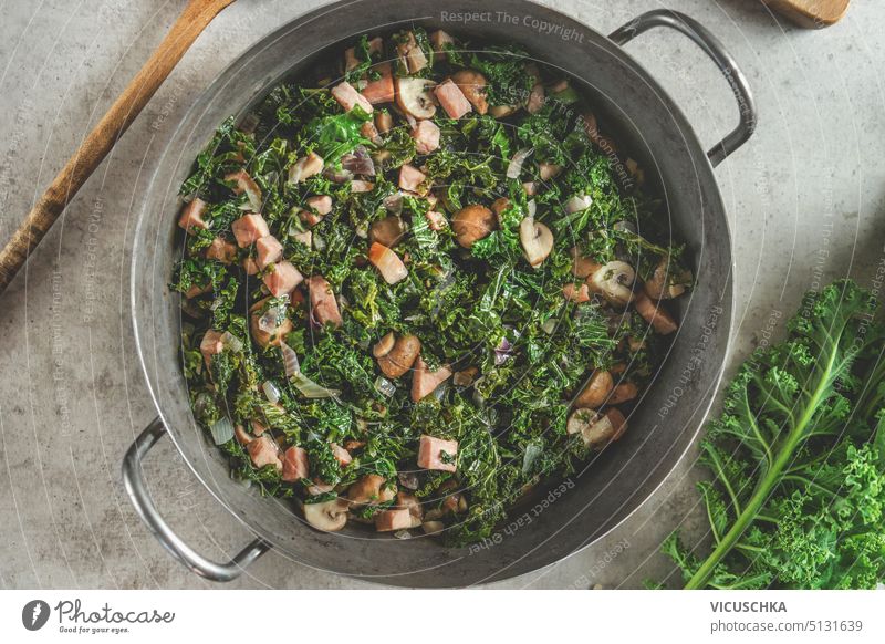 Gedünsteter Grünkohl mit Pilzen im Kochtopf. Gesundes grünes Essen. Ansicht von oben gedünstet Kale Gesundheit Draufsicht Essen zubereiten Vegetarier