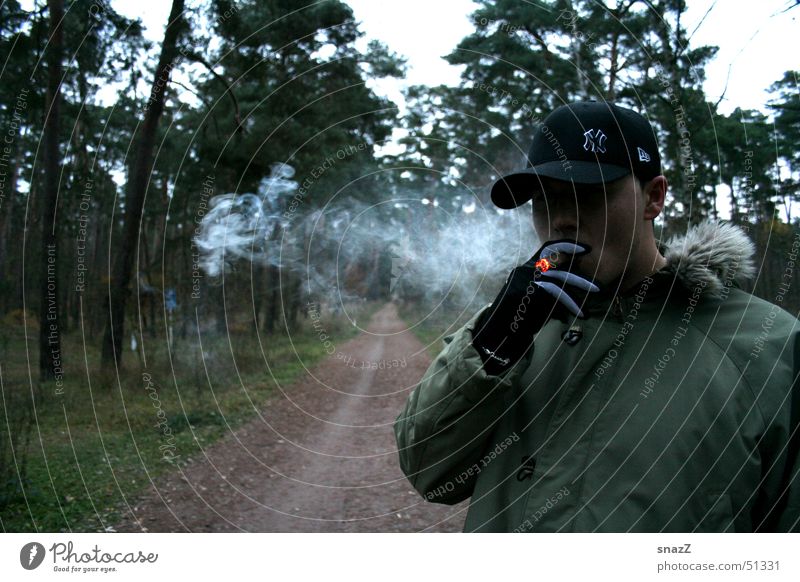 Eine kurze Pause auf dem weg zum Glück Zigarre Zigarette Baseballmütze grün beige Wald Baum schwarz Handschuhe Außenaufnahme Rauchen Gras dunkelgrün Glut