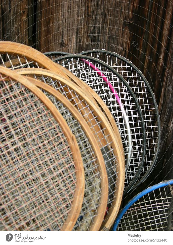 Federballschläger aus Holz und Badmintonschläger vor dem braunen Holz einer alten Scheune im Sommer in Rudersau bei Rottenbuch im Pfaffenwinkel im Kreis Weilheim-Schongau in Oberbayern