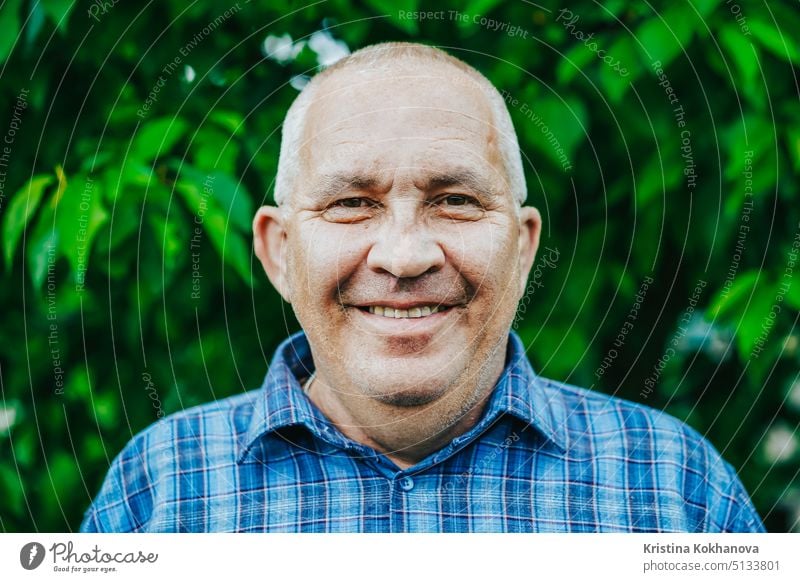 Porträt eines fröhlich lächelnden alten Mannes im Park. Kaukasischer Großvater schaut in die Kamera und lächelt Person Erwachsener männlich Lifestyle Ruhestand