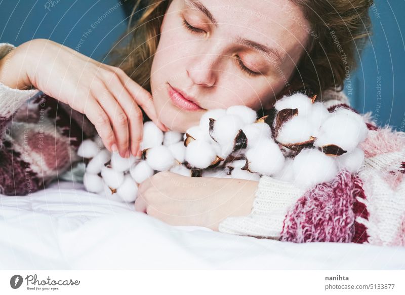 Junge Frau hält eine getrocknete Baumwollpflanze in den Händen filigran Baumwolle organisch Textil natürlich Gewebe Schönheit weich berühren taktil Weiblichkeit