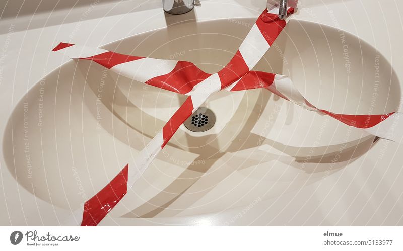 ovales Waschbecken mit über Kreuz geklebtem Absperrband Waschtisch Flatterband Trassierband Warnfarbe rot-weiß unbenutzbar Gefahrenstelle Ausstellungsstück Blog