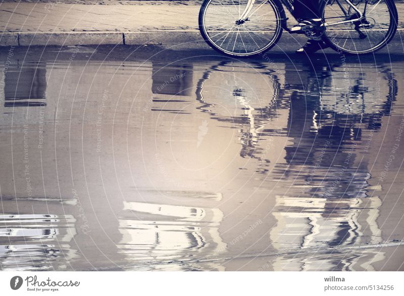Wasserwege Überschwemmung Hochwasser Straße Fahrrad Spiegelung Pfütze nass Regen überschwemmt Flut Regenwasser Wasserspiegelung Fußweg Bordsteinkante Radfahrer