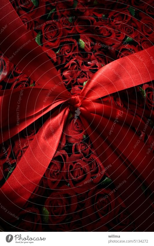 Das Geschenk - eine rote Schleife und Geschenkpapier mit Rosen Geburtstagsgeschenk Überraschung schenken Feste & Feiern Freude
