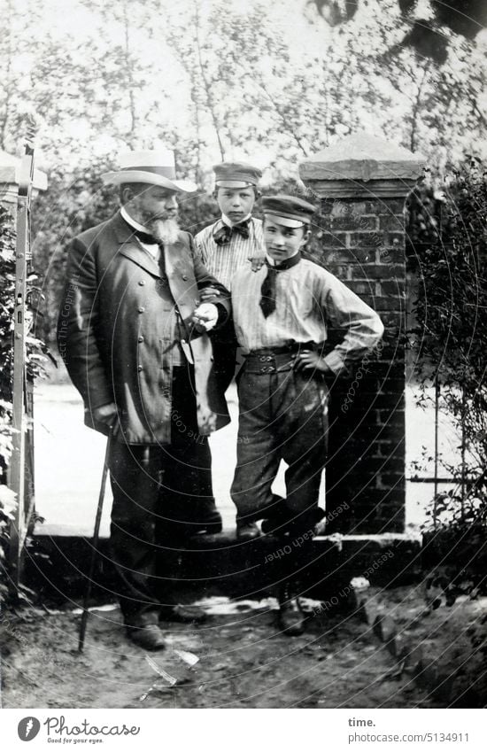 Vater mit zwei Söhnen Mann männlich portrait historisch zusammen Vertrauen stehen Blick in die Kamera Typen alt früher damals Schüler schirmmütze hut Gehstock