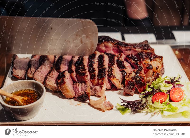 Ausgezeichnete argentinische Fleischstücke auf einem weißen Teller amerika angus Argentinien asado Hintergrund Barbecue Rindfleisch schwarz Holzplatte Holzkohle