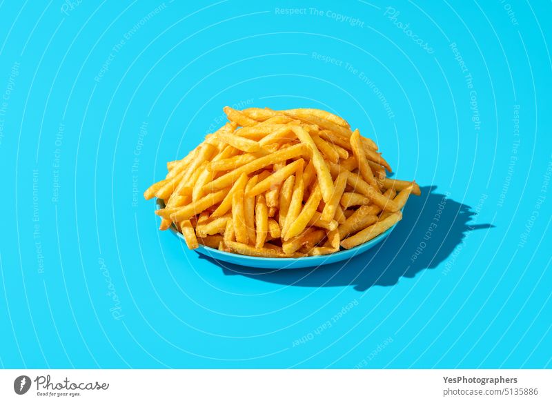 Pommes frites Teller minimalistisch auf einem blauen Hintergrund. Überfluss hell Kalorien Chip Nahaufnahme Farbe farbenfroh Komfortnahrung Konzept Textfreiraum
