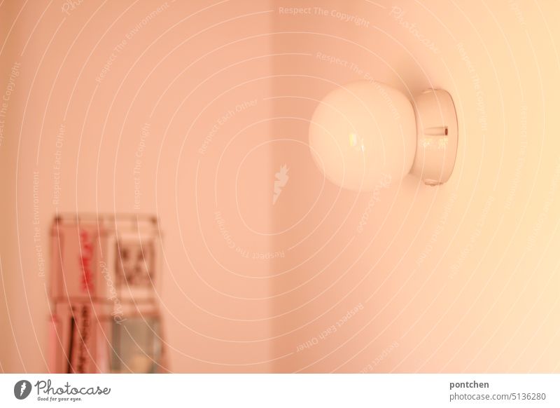 eine weiße, schlichte, wandlampe und ein postkartenständer an der wand zimmer einrichtung stil Licht wohnen raum Häusliches Leben Innenaufnahme Design
