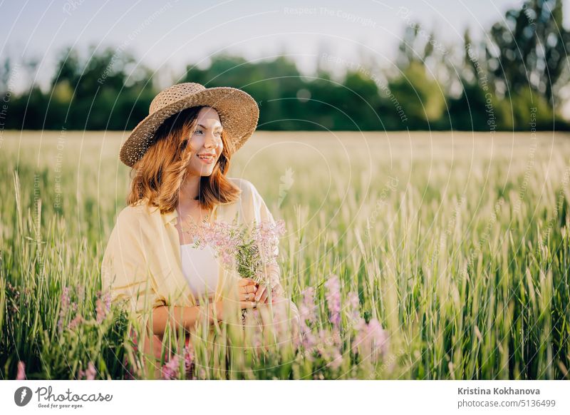 Porträt der ländlichen stilvolle Frau in Strohhut posiert in frischen Weizenfeld. Gras Hintergrund. Erstaunliche Natur, Lebensstil, Ackerland, wachsende Getreidepflanzen.