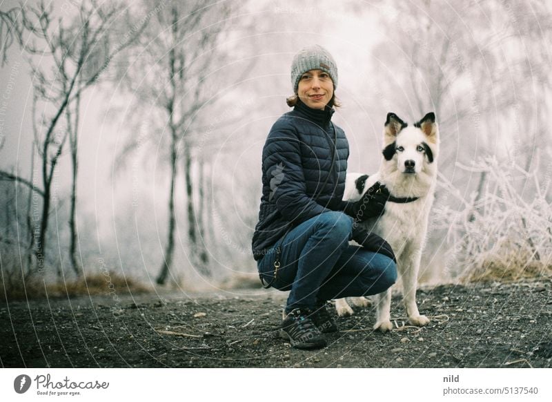 Junge Frau mit ihrem Hund in winterlicher Landschaft Kälte Raureif Team gemeinsam Freundschaft zusammen Mensch und Hund Mensch und Tier Winter Wege & Pfade