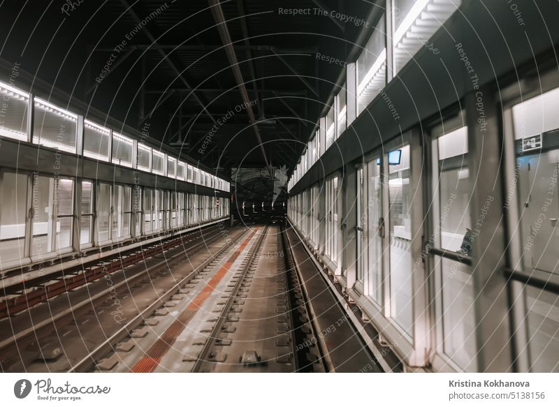 Vorderansicht eines fahrenden U-Bahn-Wagens zwischen Flughafenterminals. Fahrt mit einem fahrerlosen U-Bahn-Zug in Barcelona. Fortschrittliches Transportsystem, U-Bahn-Tunnel.
