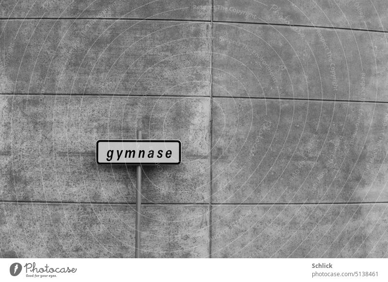 gymNase steht da in französischer Sprache auf einem Schild vor einer tristen Betonmauer und lässt nutzlosen Schweißgeruch im geschlossenen Raum erahnen gymnase