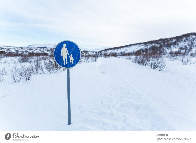 niedliches blaues Fußwegschild an einem fett verschneiten Weg in schöner Landschaft Schild Fußgänger Fußgängerschild Gehweg Mann und Kind Gender