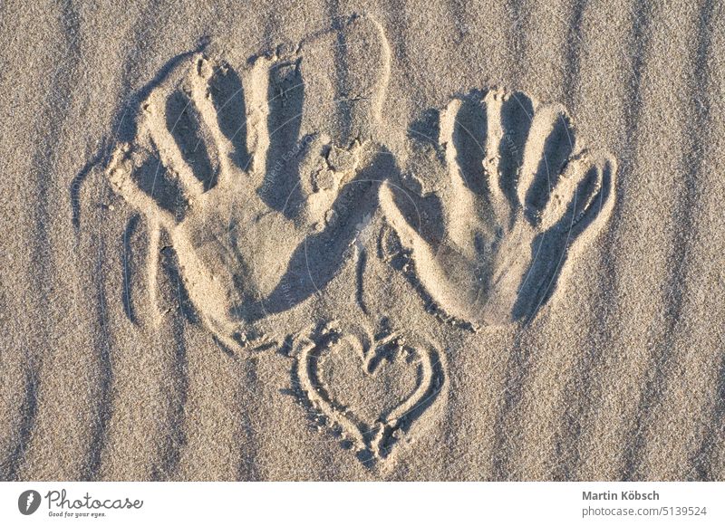 Handabdruck mit Herz im Sand am Strand. Gewellter Sand. Stilleben am Meeresstrand Finger Abdruck reisen Urlaub Wasser Perspektive Ostsee Nationalpark Zingst